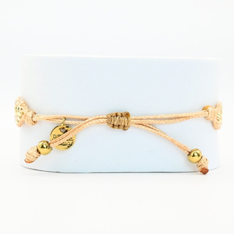 apportez une touche de luminosité à votre poignet avec cette petite manchette élégante. Composée de 5 rangs de perles dorées et nude, elle crée un contraste subtil et raffiné. L'ornement soleil au centre ajoute une note chaleureuse et scintillante, évoquant l’éclat du jour.. Bijou seul, Crédit GEMITY