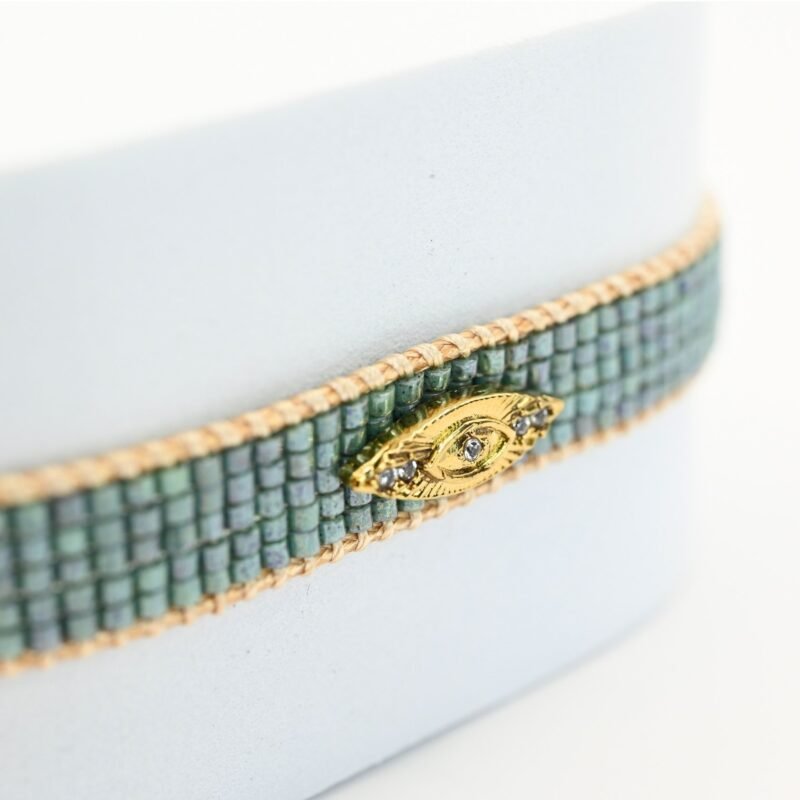 apportez une touche de mystère et de style à votre poignet avec cette petite manchette élégante, composée de 5 rangs de perles vertes vibrantes. L'ornement œil en son centre ajoute une dimension symbolique et unique à ce bijou.. Bijou seul, Crédit GEMITY