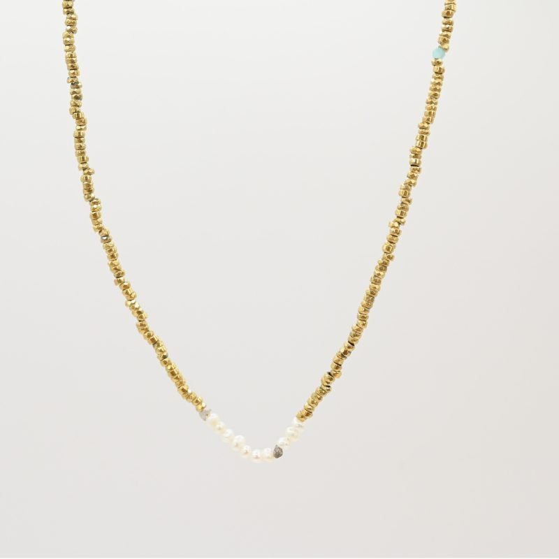 Ce bijou polyvalent se compose de petites perles dorées subtilement mises en valeur par quelques perles en nacre placées en son centre. . Bijou seul, Crédit GEMITY