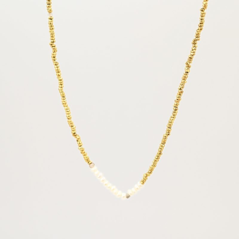 Ce bijou polyvalent se compose de petites perles dorées subtilement mises en valeur par quelques perles en nacre placées en son centre. . Bijou seul, Crédit GEMITY