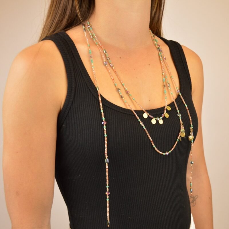 ce collier sautoir en perles roses et turquoises offre une touche de couleur éclatante et de fluidité à vos tenues.. Bijou porté, Crédit GEMITY.
