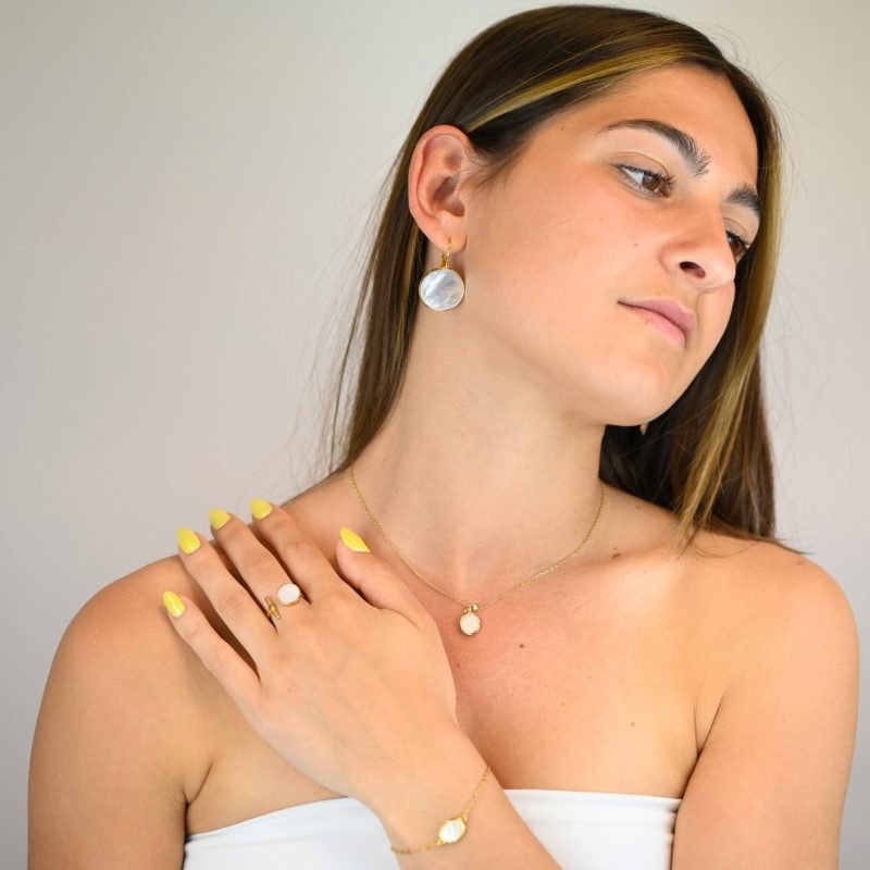"Si vous appréciez les belles nacres naturelles, vous aimerez la beauté de ce bracelet autour de votre poignet. Ce magnifique bijou est doré à l’or fin 24 carats. Ce bracelet de 15 cm est ajustable avec sa chaîne d’extension. Cette pièce apportera une touche créative à vos tenues dans un style épuré. . Bijou porté, Crédit GEMITY."