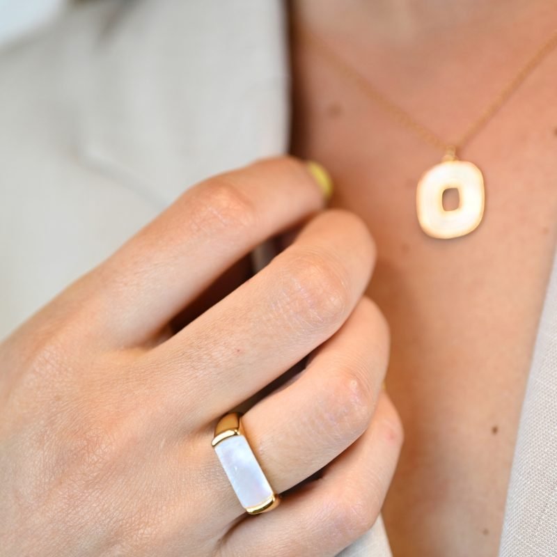"La couleur blanche de la nacre naturelle s’associera avec tout votre dressing. Une nacre naturelle’ qui a été récupérée en Asie chez le producteur lors de nombreux voyages. Bague nacre RÉGLABLE Composition : métal doré à l'or fin 24 cts . Bijou porté, Crédit GEMITY."
