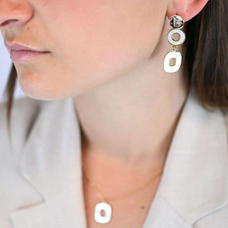"Collier avec une nacre naturelle montée sur du métal doré à l’or fin 24 carats. La longueur de la chaîne est de 40 cm + chaînette de rallonge. . Bijou porté, Crédit GEMITY."