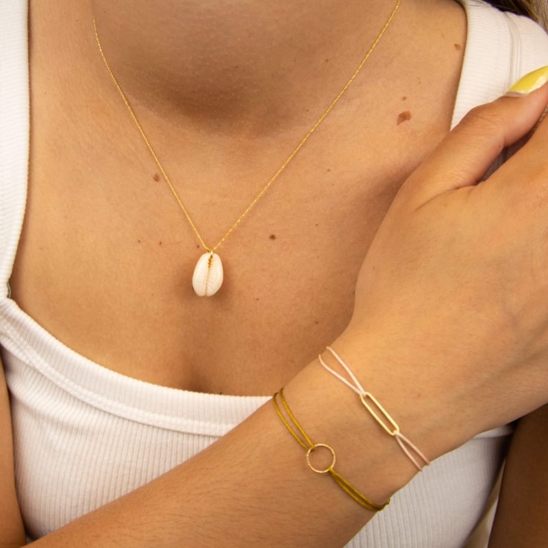 "Collier plaqué or (3 microns) coquillage émaillé Véritable cauri (coquillage) d’une longueur d’environ 2 cm Taille de la chaîne : 39 cm (+5cm de chaîne de rappel) . Bijou seul, Crédit GEMITY"