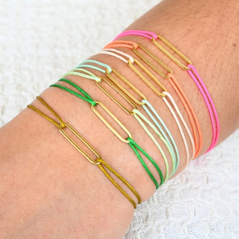 "Bracelet avec un maillon en plaqué or (3 microns) et un cordon coloré. Taille ajustable. . Bijou porté, Crédit GEMITY."