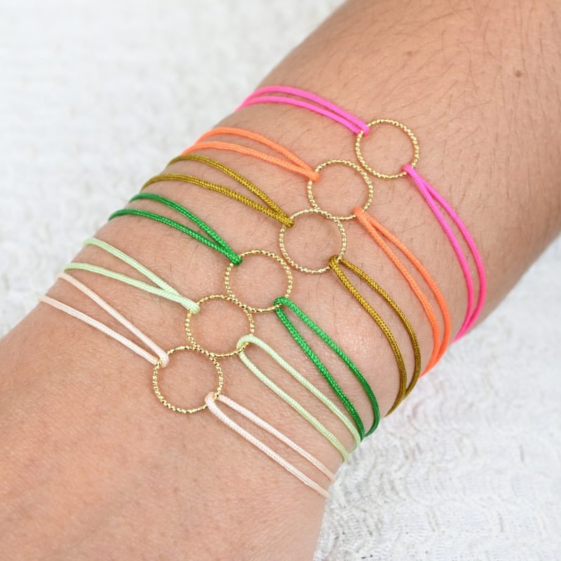Bracelets de l'amitié, vendu par deux. Cercle en plaqué or (3 microns). Le bracelet est en tissu et vous retrouvez en son centre un magnifique cercle en plaqué or. . Bijou porté, Crédit GEMITY.