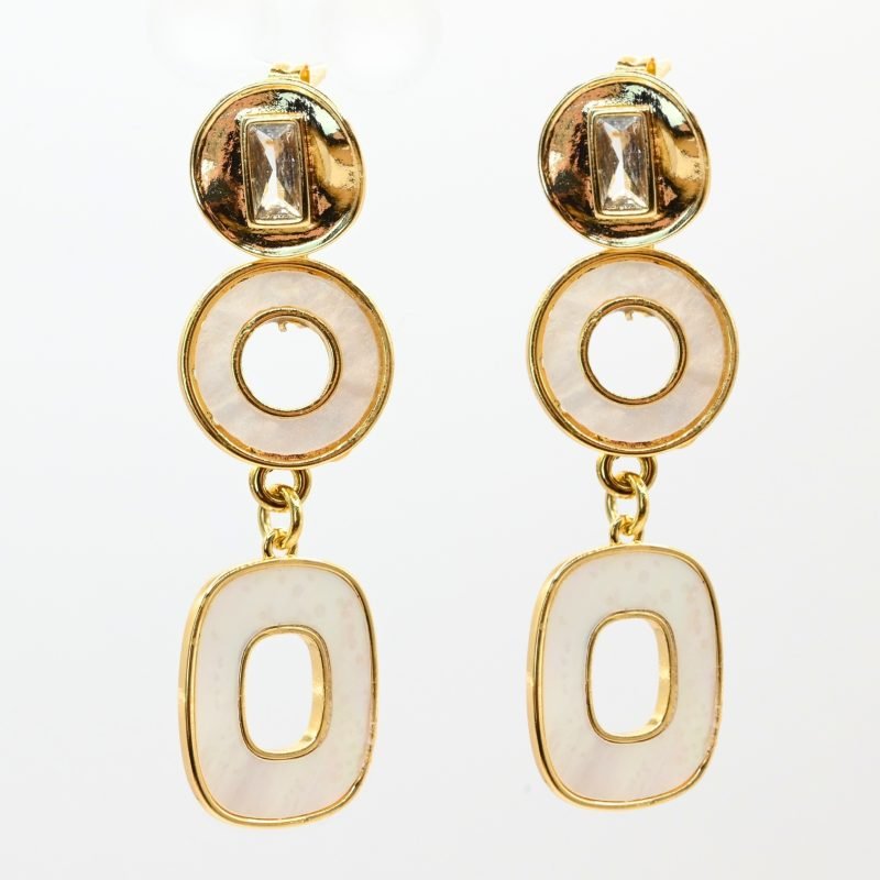 "Boucles d’oreilles à tige en métal doré à l’or fin et pendant en métal doré et nacres naturelles. Ces charmantes boucles d’oreilles fantaisie en plaqué or sont sont un excellent ajout à tout autre bijoux. Elles ne provoquent pas d'allergies au nickel. Taille : 6 cm . Bijou seul, Crédit GEMITY"
