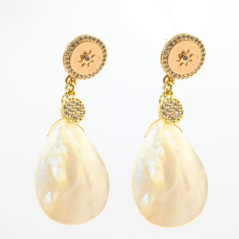 "Boucles d’oreilles en métal, zircons et nacre naturelle. Le pendentif mesure environ 2.5 cm. La nacre Keishi est réputée pour son aspect incomparable. Ce bijou se portera avec délicatesse contre votre peau. . Bijou seul, Crédit GEMITY"