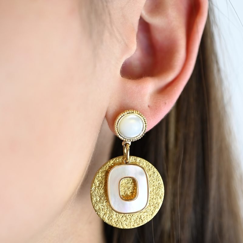 Composition : Boucles d'oreilles en métal et nacre naturelle, hauteur 24 mm. Une nacre naturelle qui se portera avec délicatesse contre votre peau.. Bijou porté, Crédit GEMITY.
