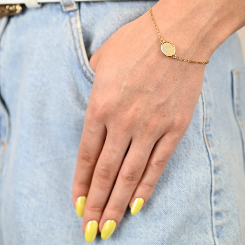 "Si vous appréciez les belles nacres naturelles, vous aimerez la beauté de ce bracelet autour de votre poignet. Ce magnifique bijou est doré à l’or fin 24 carats. Ce bracelet de 15 cm est ajustable avec sa chaîne d’extension. Cette pièce apportera une touche créative à vos tenues dans un style épuré. . Bijou porté, Crédit GEMITY."