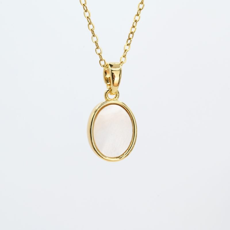 "Collier avec une nacre naturelle montée sur métal doré à l’or fin avec un pendentif en nacre ovale de 1 cm. La longueur de la chaîne est de 40 cm + chaînette de rallonge. . Bijou seul, Crédit GEMITY"