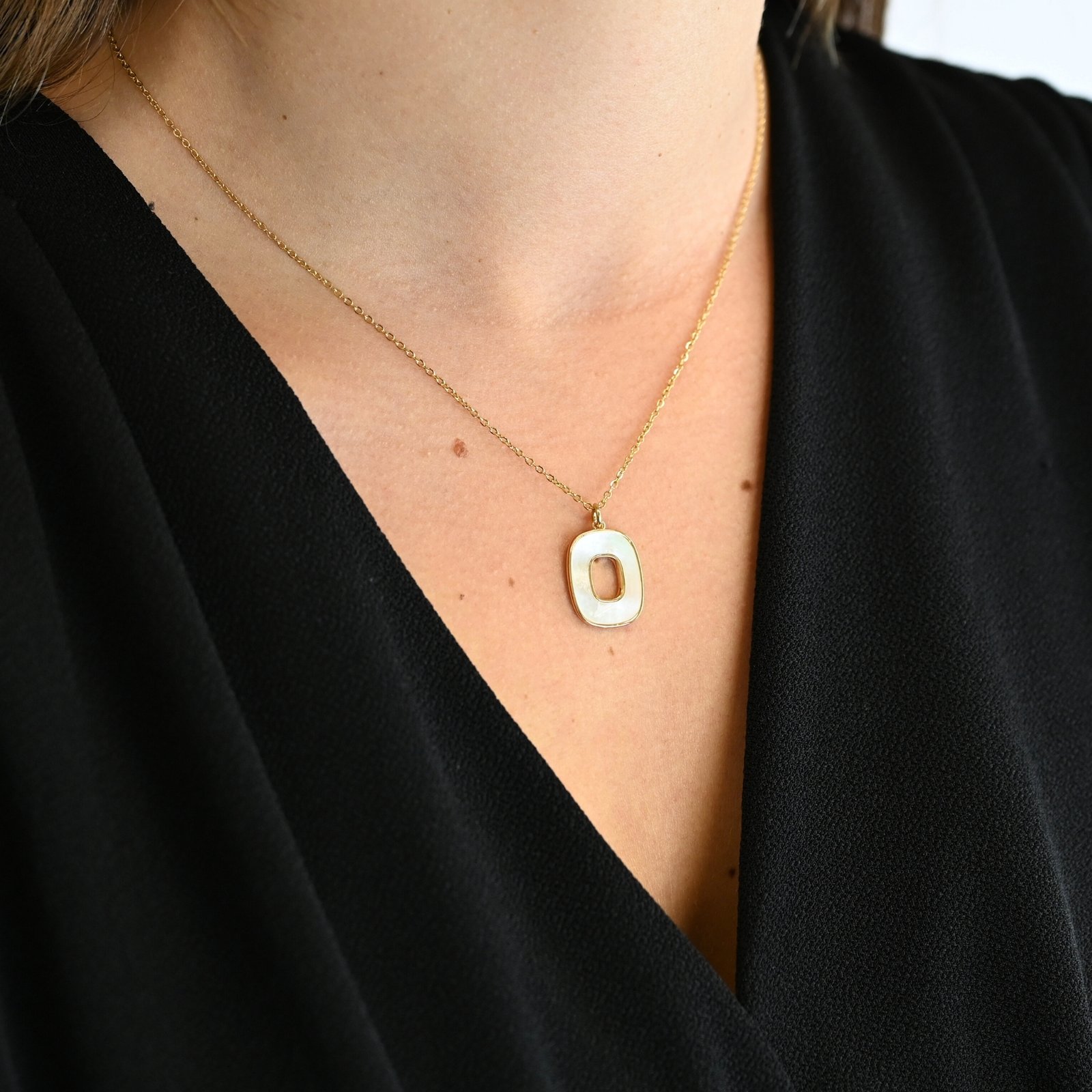 "Collier avec une nacre naturelle montée sur du métal doré à l’or fin 24 carats. La longueur de la chaîne est de 40 cm + chaînette de rallonge. . Bijou porté, Crédit GEMITY."