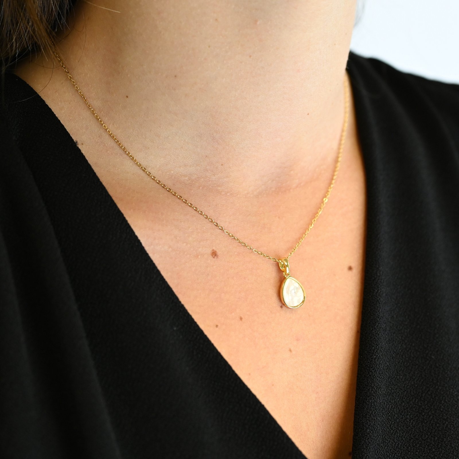 "Collier avec un nacre naturelle montée sur métal doré à l’or fin 24 carats avec un pendentif en forme de goutte d’eau de 1 cm de longueur. La longueur de la chaîne est de 40 cm + chaînette de rallonge. . Bijou porté, Crédit GEMITY."