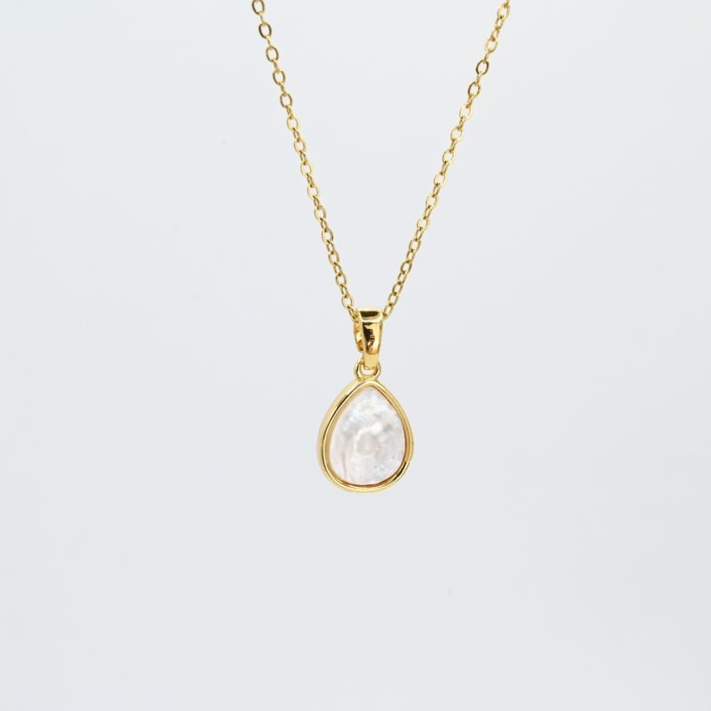 "Collier avec un nacre naturelle montée sur métal doré à l’or fin 24 carats avec un pendentif en forme de goutte d’eau de 1 cm de longueur. La longueur de la chaîne est de 40 cm + chaînette de rallonge. . Bijou seul, Crédit GEMITY"