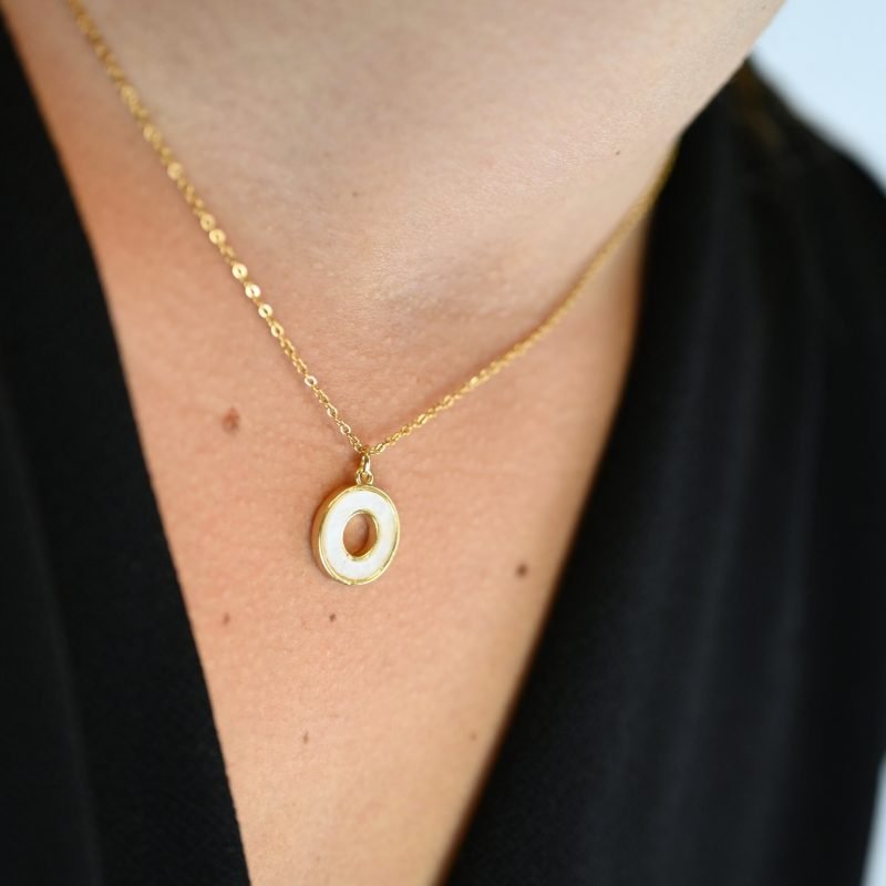"Collier composé d’un pendentif en nacre naturelle montée sur métal doré à l’or fin 24 carats. La longueur de la chaîne est de 40 cm + chaînette de rallonge. . Bijou porté, Crédit GEMITY."