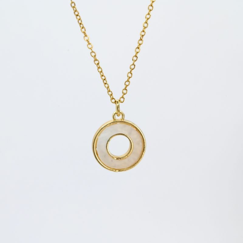 "Collier composé d’un pendentif en nacre naturelle montée sur métal doré à l’or fin 24 carats. La longueur de la chaîne est de 40 cm + chaînette de rallonge. . Bijou seul, Crédit GEMITY"