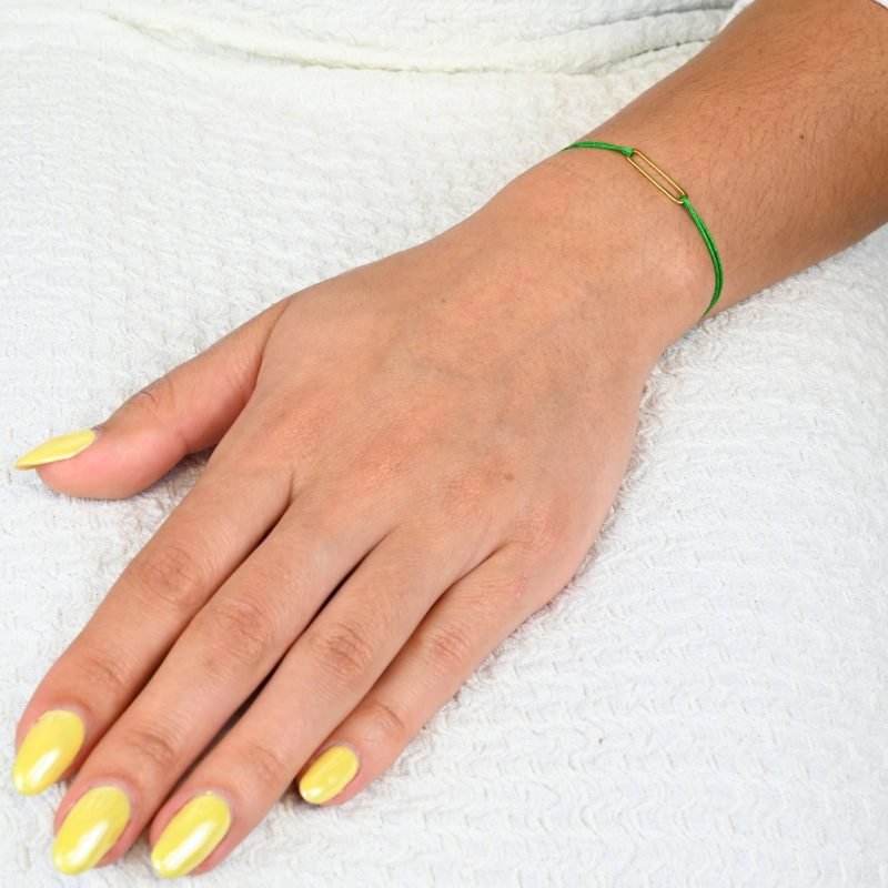 "Bracelet avec un maillon en plaqué or (3 microns) et un cordon coloré. Taille ajustable. . Bijou porté, Crédit GEMITY."
