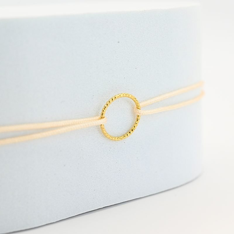 Bracelets de l'amitié, vendu par deux. Cercle en plaqué or (3 microns). Le bracelet est en tissu et vous retrouvez en son centre un magnifique cercle en plaqué or. . Bijou seul, Crédit GEMITY