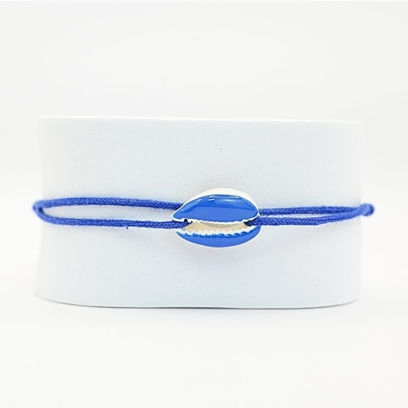 "Véritable cauri émaillé (longueur ≈ 1,5 cm) de la même couleur que le cordon. Lien cordon en coton ajustable, convient pour des poignets de 14 à 19 cm.. Bijou seul, Crédit GEMITY"