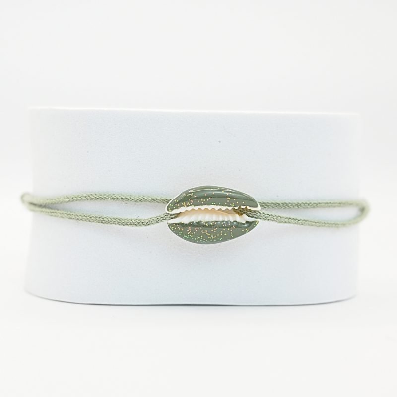 "Véritable cauri émaillé (longueur ≈ 1,5 cm) de la même couleur que le cordon. Lien cordon en coton ajustable, convient pour des poignets de 14 à 19 cm.. Bijou seul, Crédit GEMITY"