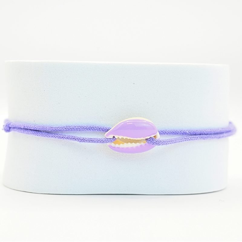 "Véritable cauri émaillé (longueur ≈ 1,5 cm) de la même couleur que le cordon. Lien cordon en coton ajustable, convient pour des poignets de 14 à 19 cm.. Bijou seul, Crédit GEMITY"