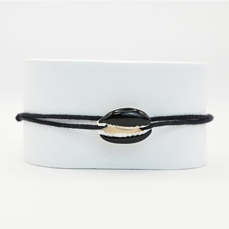 "Véritable cauri émaillé (longueur ≈ 1,5 cm) de la même couleur que le cordon. Lien cordon en coton ajustable, convient pour des poignets de 14 à 19 cm.. Bijou seul, Crédit GEMITY"