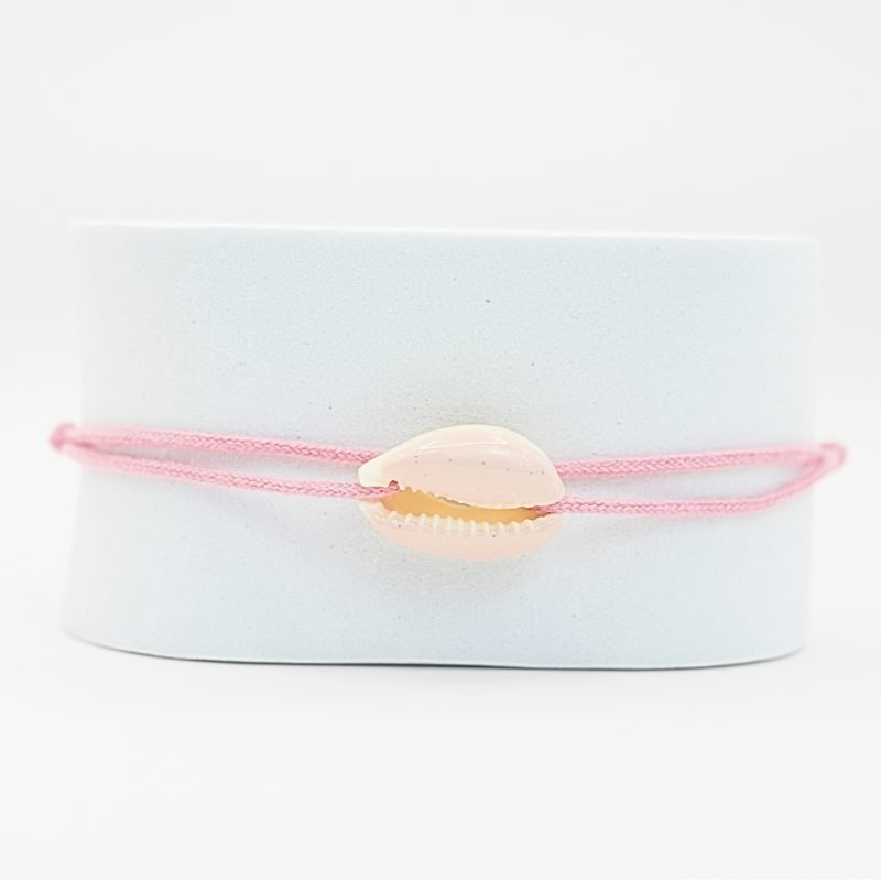 "Véritable cauri émaillé (longueur ≈ 1,5 cm) de la même couleur que le cordon. Lien cordon en coton ajustable, convient pour des poignets de 14 à 19 cm.. Bijou seul, Crédit GEMITY"