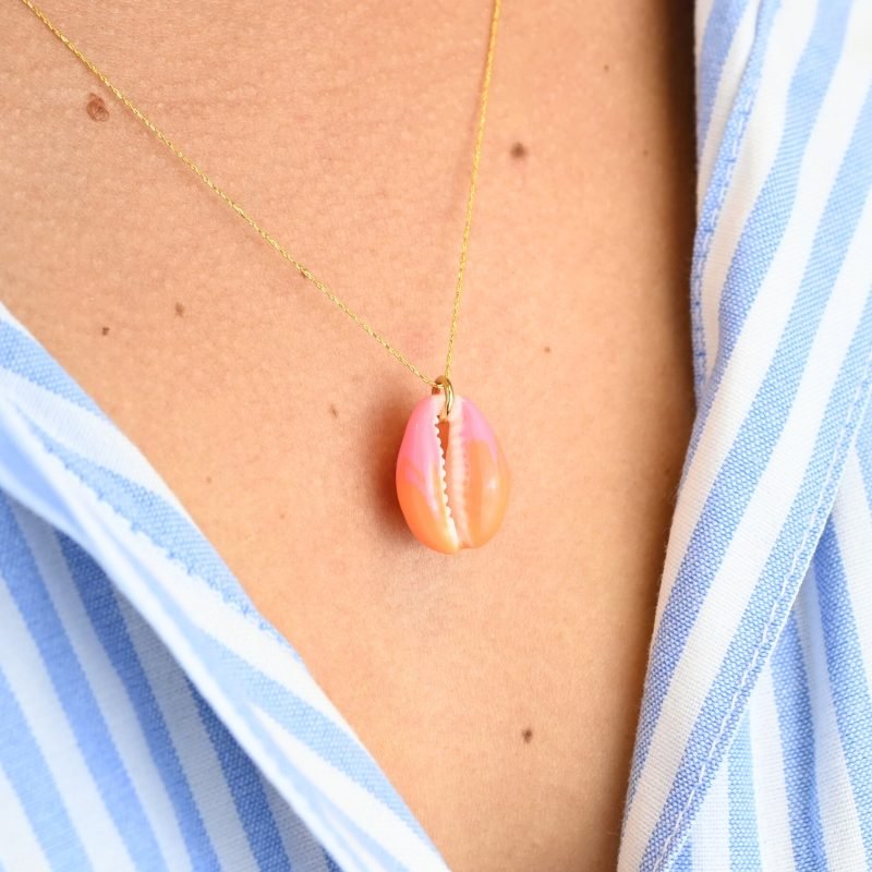 "Collier plaqué or (3 microns) coquillage émaillé Véritable cauri (coquillage) d’une longueur d’environ 2 cm Taille de la chaîne : 39 cm (+5cm de chaîne de rappel) . Bijou seul, Crédit GEMITY"