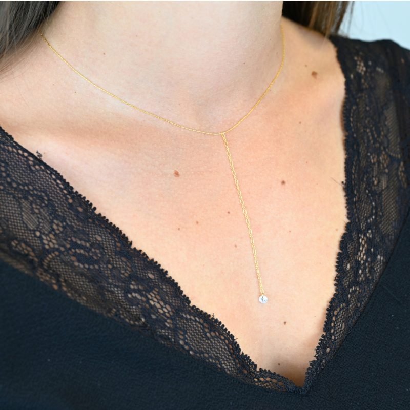 "Collier en plaqué or avec zirconium. Longueur du pendentif : 8 cm Taille de la chaîne : 39 cm (+5 cm de chaine de rappel) . Bijou porté, Crédit GEMITY."