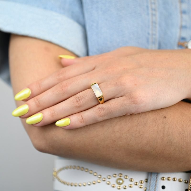 "La couleur blanche de la nacre naturelle s’associera avec tout votre dressing. Une nacre naturelle’ qui a été récupérée en Asie chez le producteur lors de nombreux voyages. Bague nacre RÉGLABLE Composition : métal doré à l'or fin 24 cts . Bijou porté, Crédit GEMITY."