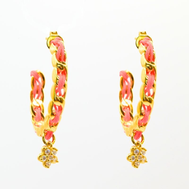 "Les boucles d'oreilles Monsens, inspirées de la collection Couture, où l'on retrouve un célèbre charm et une couleur dominante dans la maille. Taille : 27 mm de diamètre Composition : plaqué or et fil de coton.. Bijou seul, Crédit GEMITY"