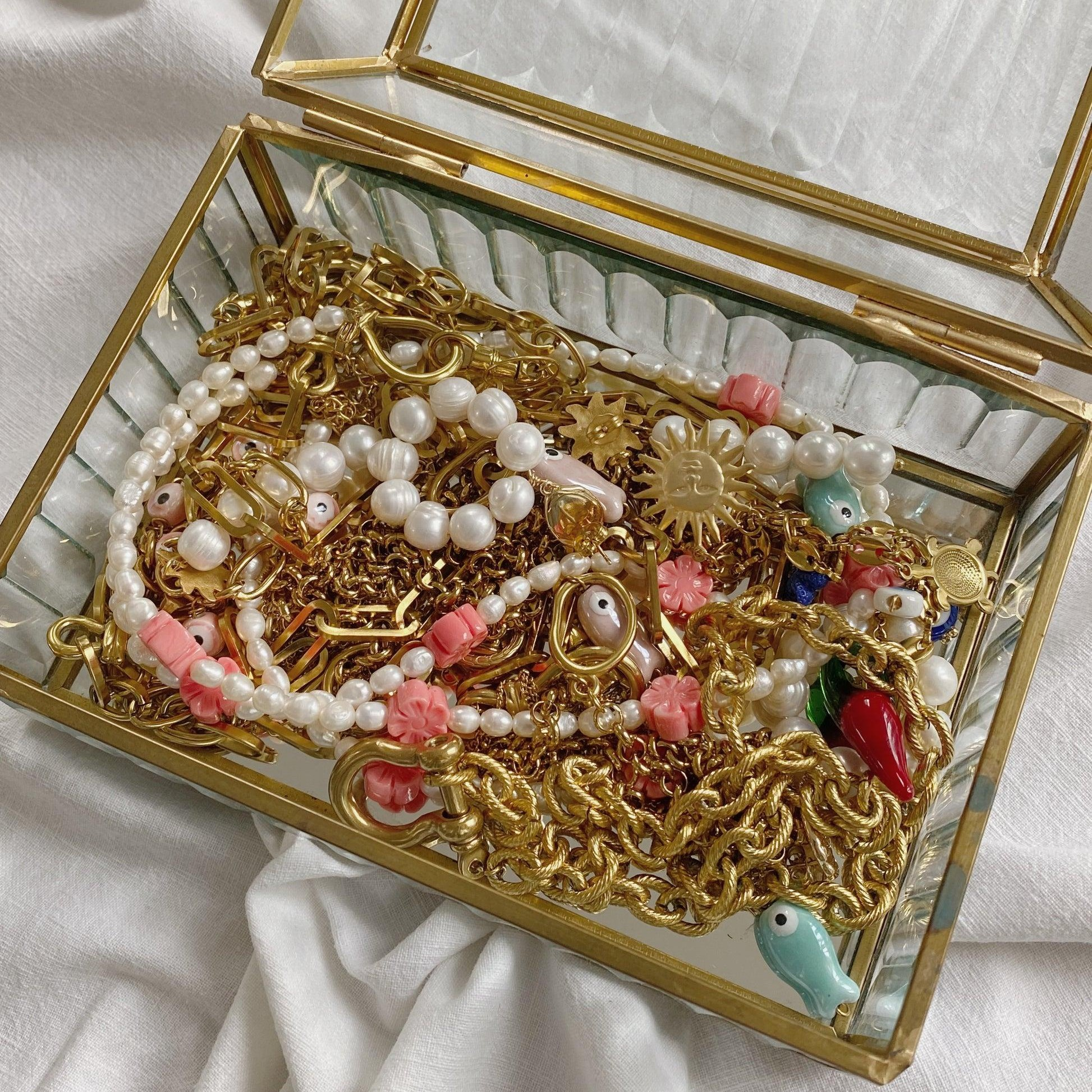 Colliers emmêlés dans une boîte à bijoux traditionnelle.